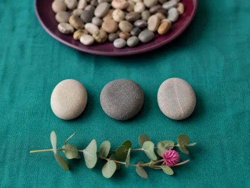 Three stones in a row apart from a pile of pebbles, one to three behaviour support plan strategies at a time.