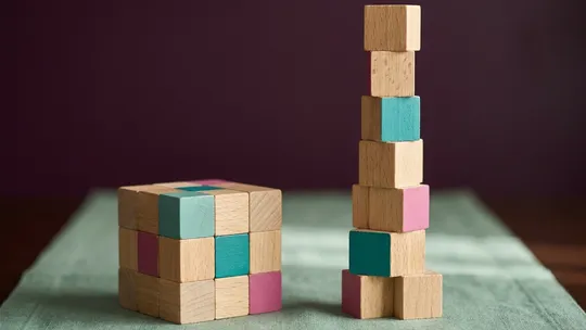 Wooden blocks in two groups, a steady base and a rising tower, for NDIS core versus capacity building.